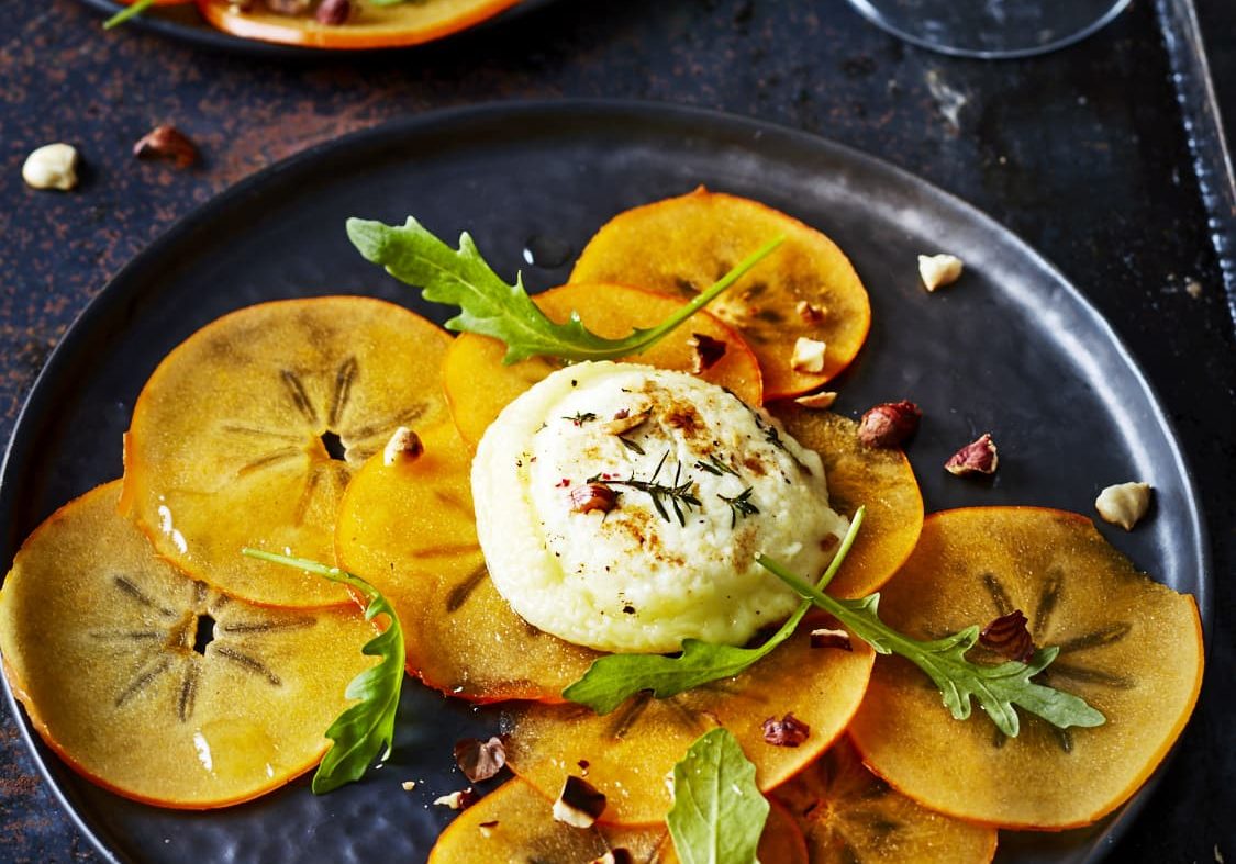 Carpaccio de kaki, roquette, noisettes et chèvre chaud